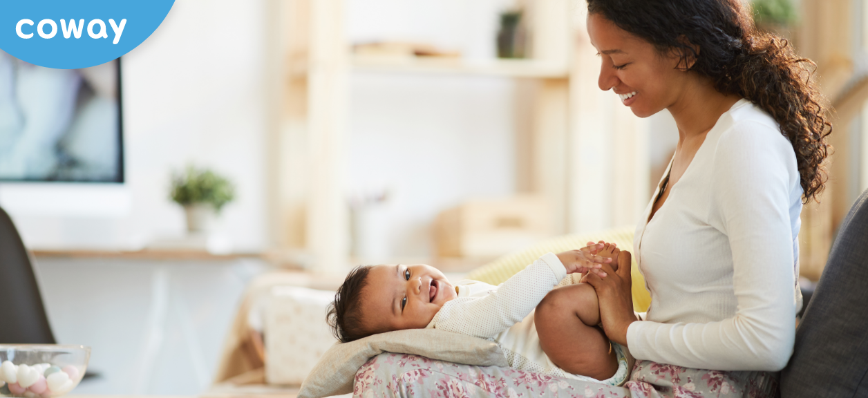 Woman smiling with baby laying in her lap