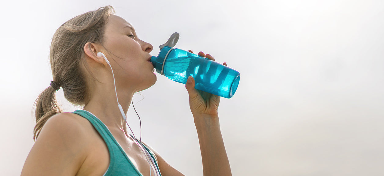 woman drinking from water bottle