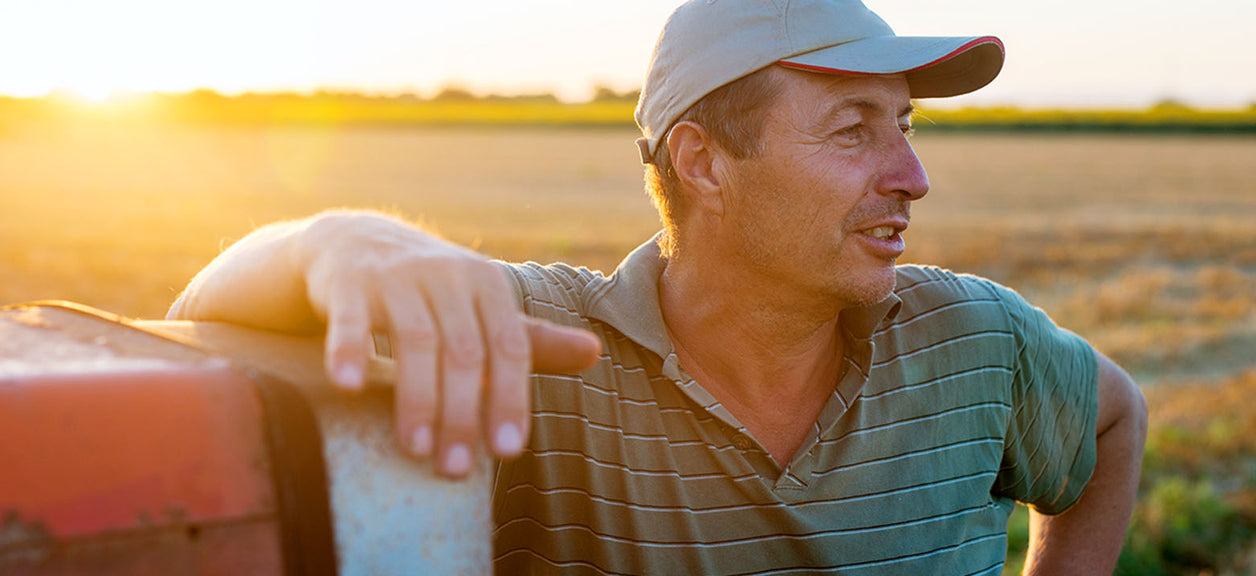 An American man leaning on car with sunset in background