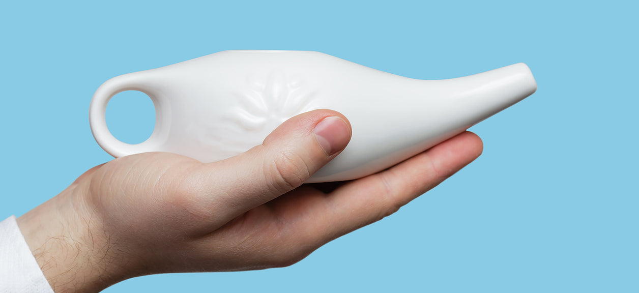 hand holding neti pot