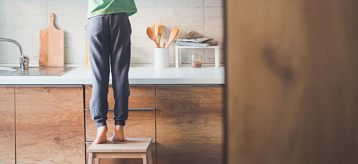 person standing on step stool cleaning