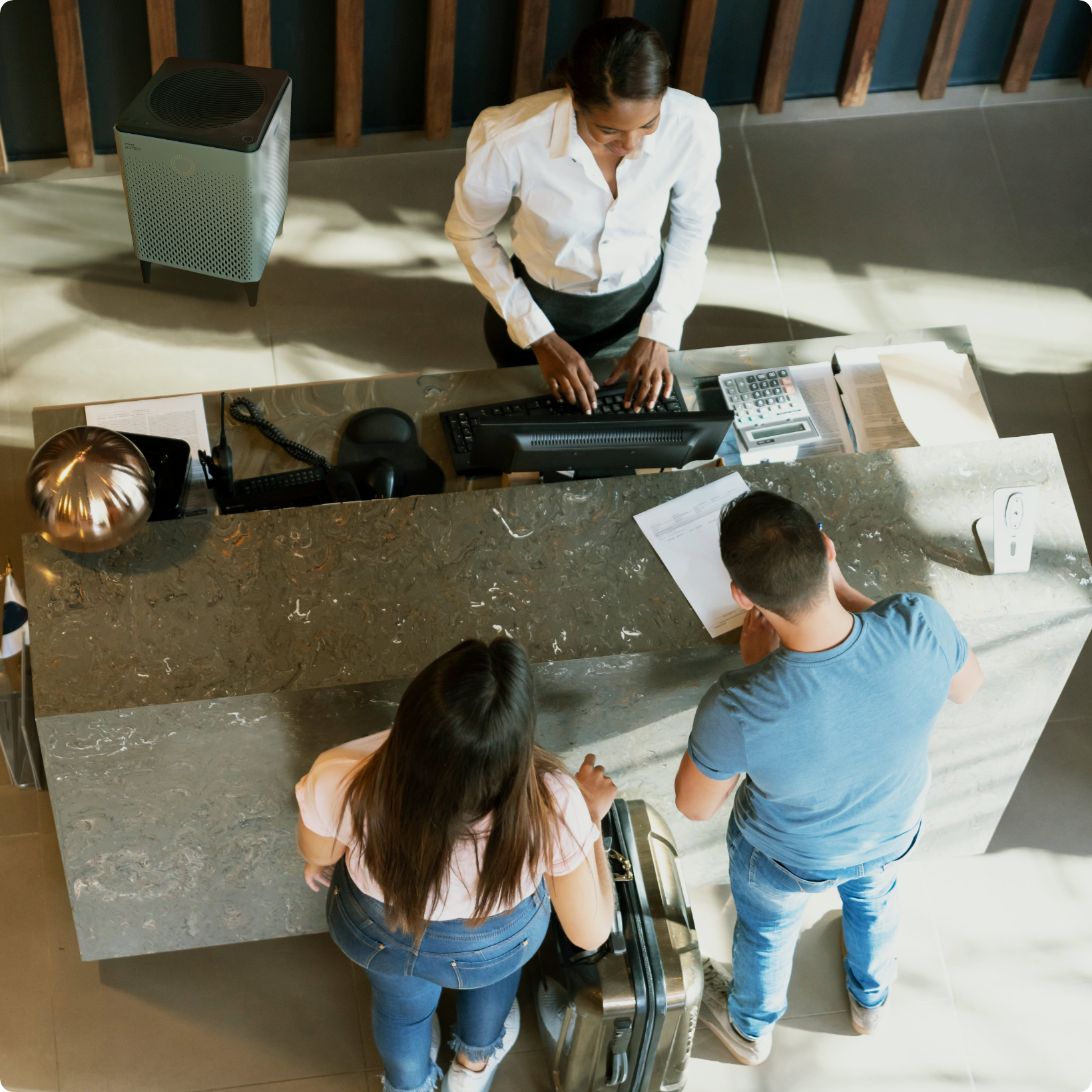 Couple checking into from desk with Airmega air purifier