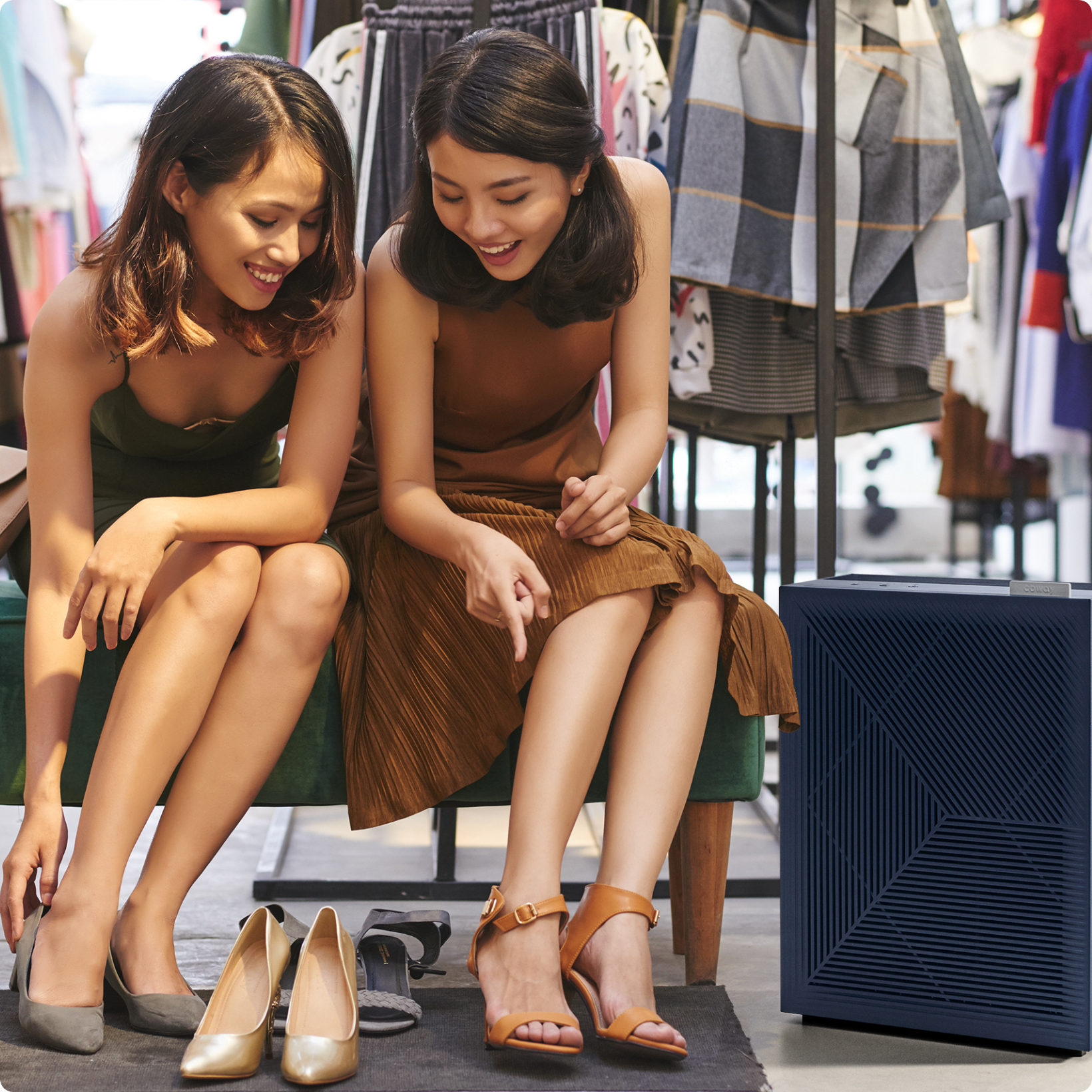 Women trying on shoes in a retail store with Airmega air purifier
