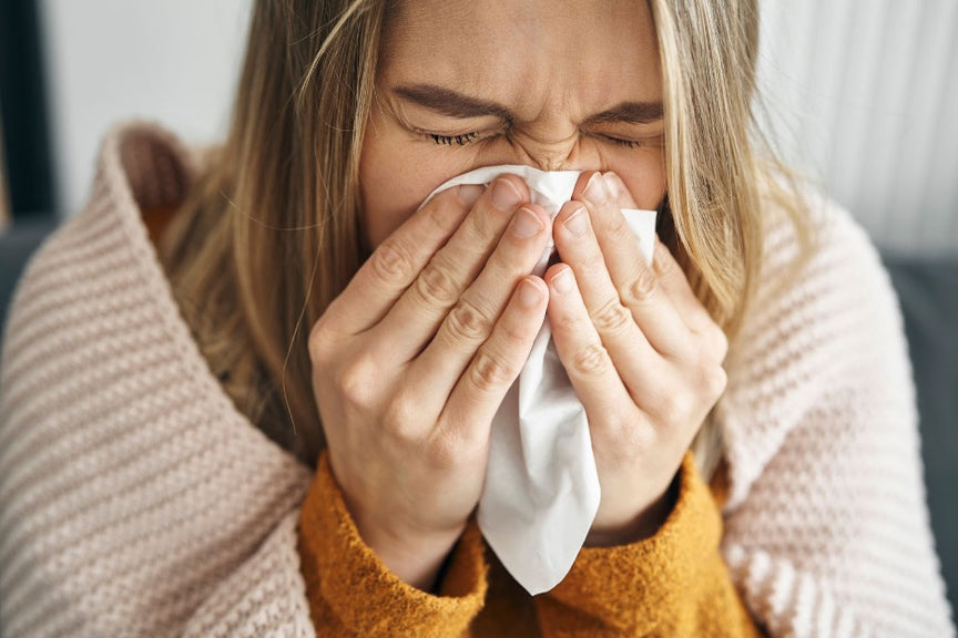 A woman sneezing during cold and flu season.