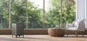 Air purifier in front of windows looking out to trees for green living.