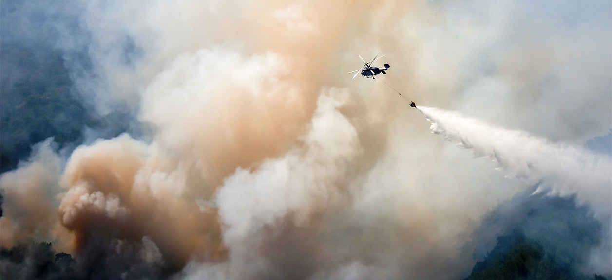 helicopter dropping sand on wildfire