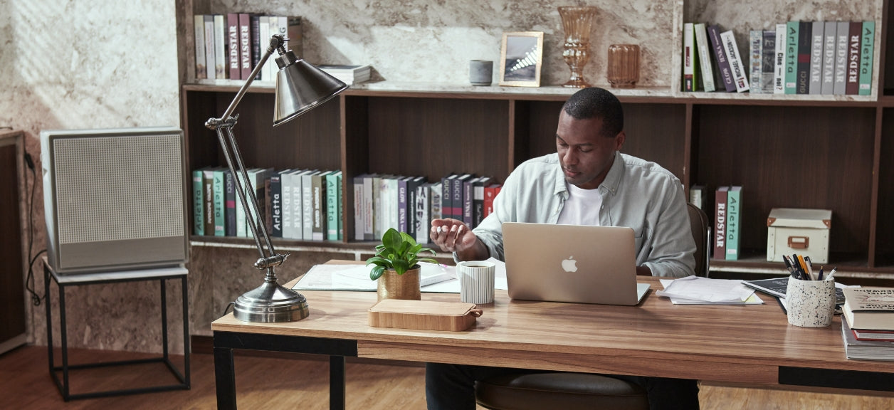 A man working in his office with an Airmega 250 beside him