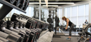 Woman in a gym working out with a set of dumbbells