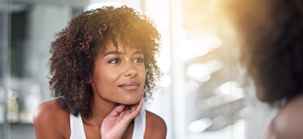 woman looking at reflection in mirror