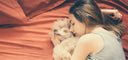 woman sleeping on bed with dog