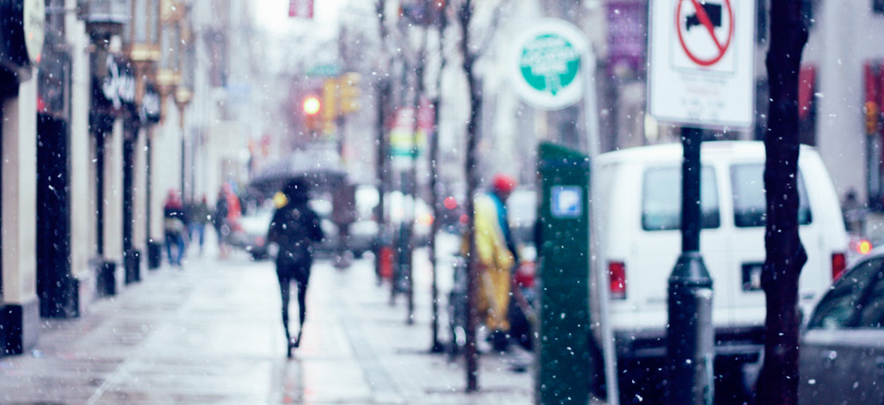 person walking down a city street in the rain