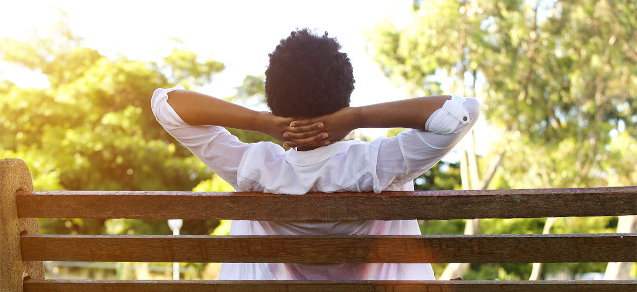 Woman on bench with hands behind her head