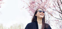 woman smiling under pink tree
