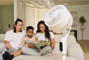 A family reading behind the Airmega Pedestal Fan P50.