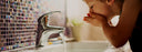 child washing face in sink