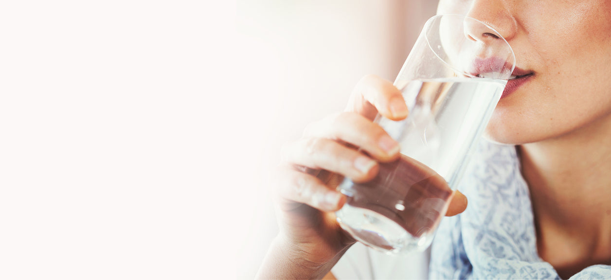 person drinking water from glass