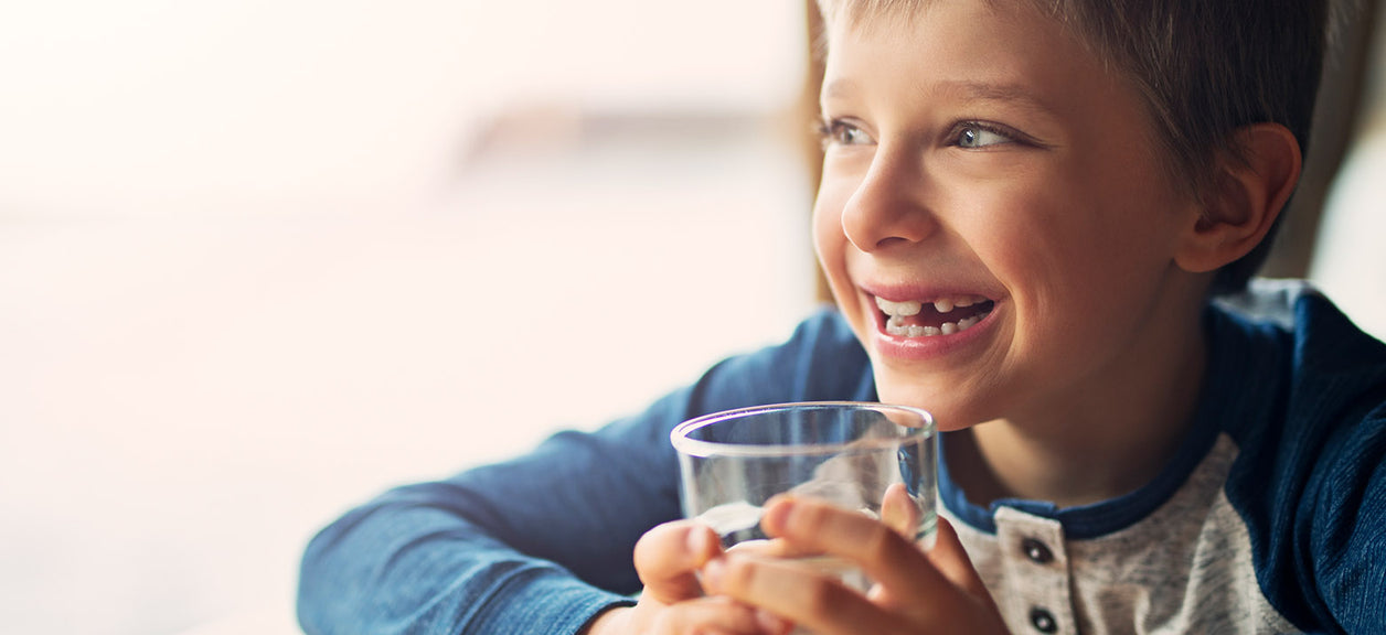 child holding glass of water