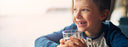 child holding glass of water