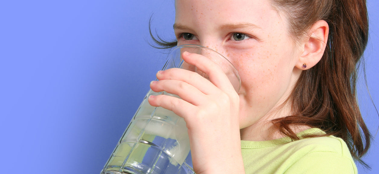 child drinking water from glass