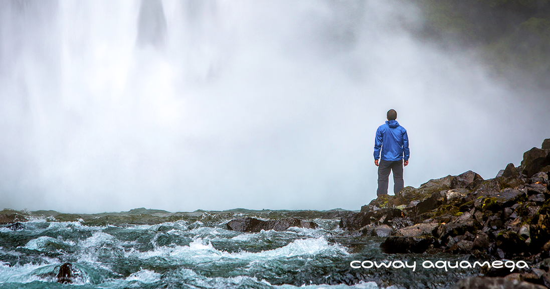 man standing on rocks near water