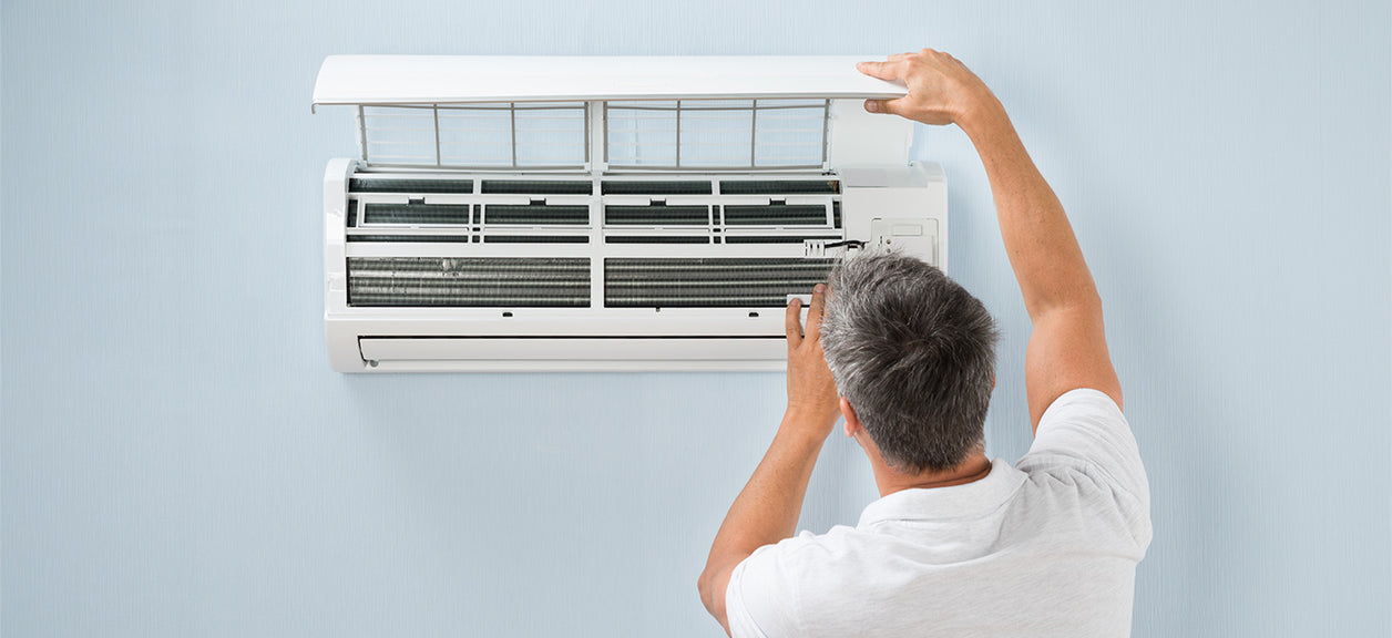 man changing air filter in air conditioner