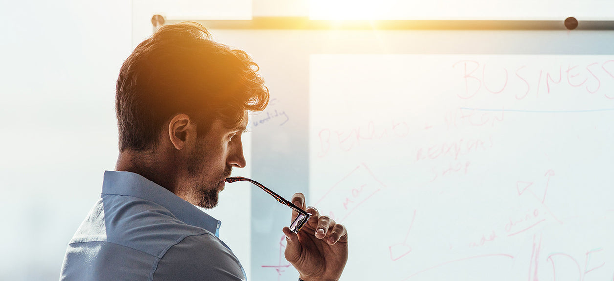 man at office holding glasses