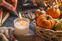 A person lighting autumn candles in their home.