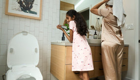 A parent and child next to a bidet.