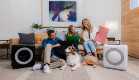 A family and their dog opening an air purifier gift.