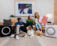 A family and their dog opening an air purifier gift.