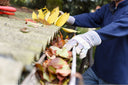 A person completing their fall cleaning checklist outdoors.