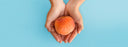 hands holding an orange