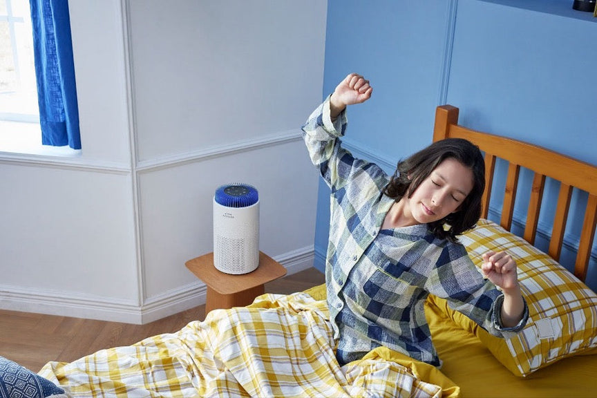 A person waking up in their bedroom in the morning with the Airmega 50.