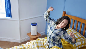 A person waking up in their bedroom in the morning with the Airmega 50.