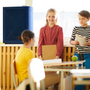 Children in classroom standing by Airmega air purifier