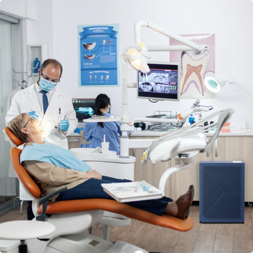 Dentist attending to patient with Airmega air purifier in the room