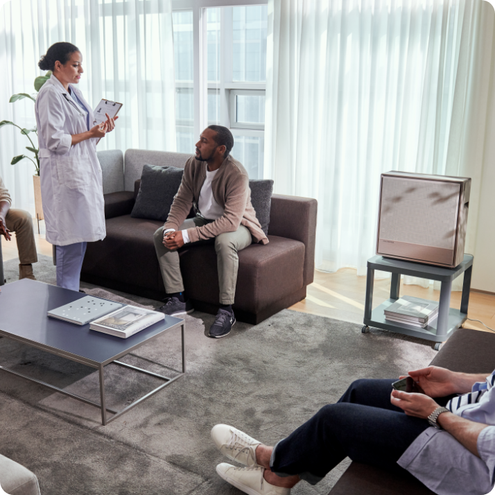 Doctor speaking to patients in waiting room with Airmega air purifier